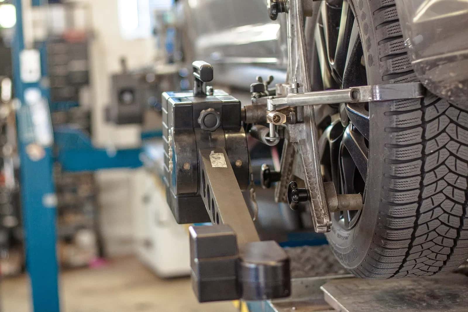 Messkopf eines Vermessungssystems am Rad eines Fahrzeugs in einer Werkstatt